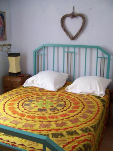 Maison d'artiste في Sainte-Colombe-en-Bruilhois: غرفة نوم بها سرير وعليها قلب على الحائط