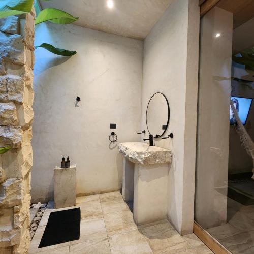 a bathroom with a sink and a mirror on the wall at Casa Josefina in Hunucmá