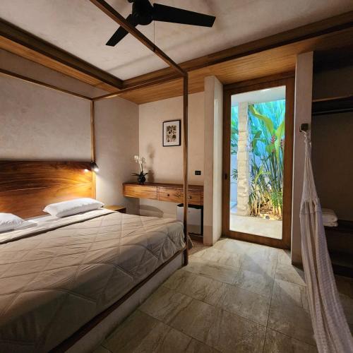 a bedroom with a bed and a large window at Casa Josefina in Hunucmá