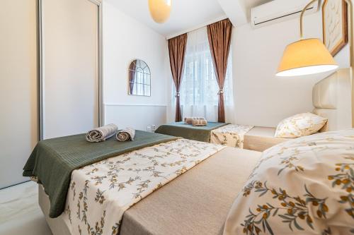 a bedroom with two beds and a window at Apartments TIME in Kotor