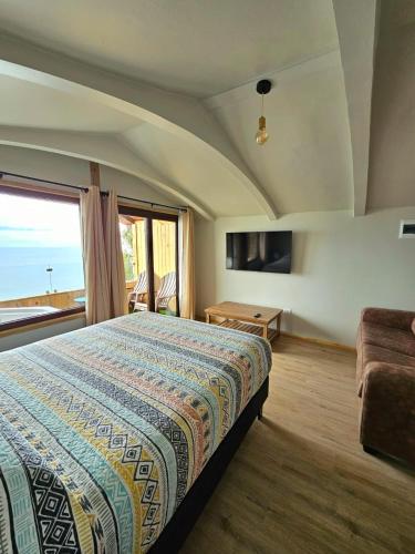 a bedroom with a bed and a large window at Al Mar Cabañas in Viña del Mar