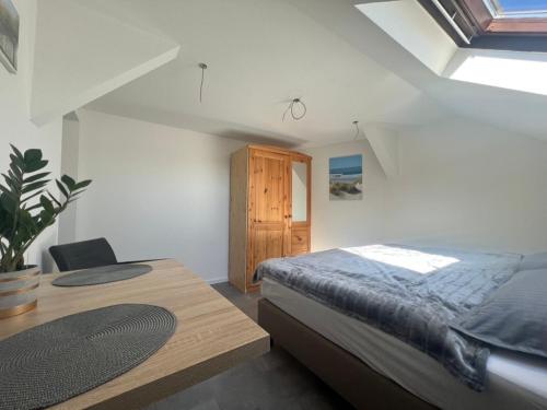 a bedroom with a bed and a wooden table at Tiny Studiowohnung Bahnhofstrasse 20 in Netzschkau