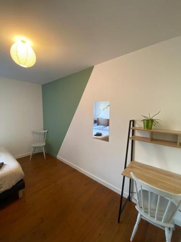 a room with a bed and a table and a desk at Gîte les Herbiers in Les Herbiers