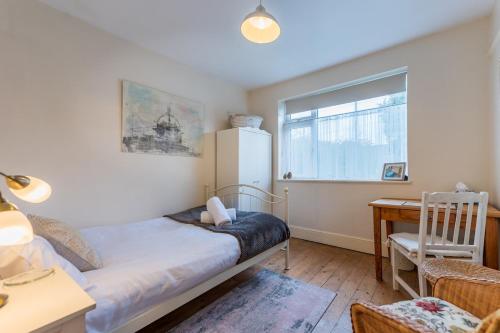 a bedroom with a bed and a desk and a window at Spacious 4 bed home to sleep 9, parking for 4 cars in Shrewsbury