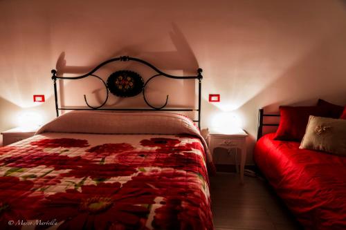 a bedroom with a bed with a red blanket and two lamps at Hotel Pina Ristorante in Isola del Gran Sasso dʼItalia