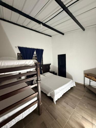 a bedroom with two bunk beds and a wooden floor at Finca Campestre - Villa Esther con Piscina en Mesitas del Colegio in El Colegio