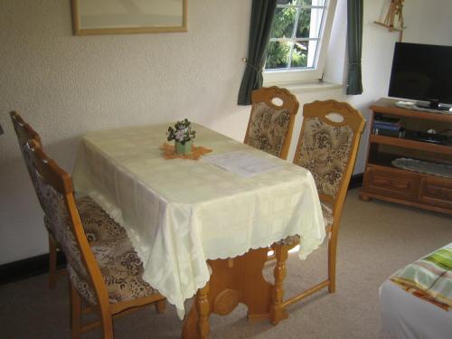 a table with a white table cloth and two chairs at Apartment Schlafwandler in Steinigtwolmsdorf
