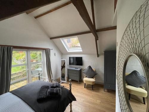 a bedroom with a bed and a window and a tv at Court Cottage - cosy traditional cottage near lovely beaches in Kingsbridge