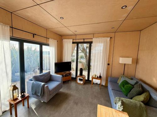 a living room with a couch and a tv at The Timber Lodge - Sennen Holiday Home in Sennen