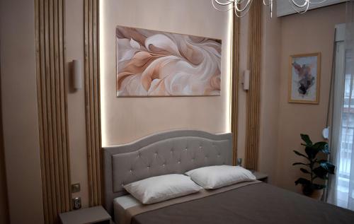 a bedroom with a bed with a painting on the wall at Galleria Home in Serres