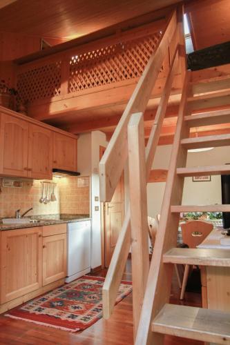 a kitchen with wooden cabinets and a spiral staircase at Residence Salvan in Corvara in Badia
