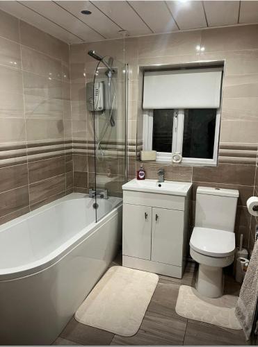 a bathroom with a tub and a toilet and a sink at Pats Place in Liverpool