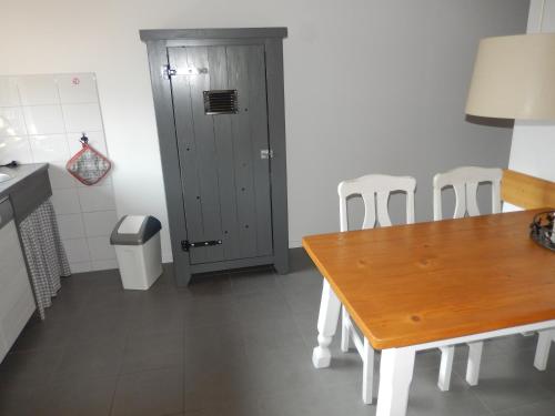 a kitchen with a wooden table and chairs and a door at Haus am Wald in Steindorf am Ossiacher See