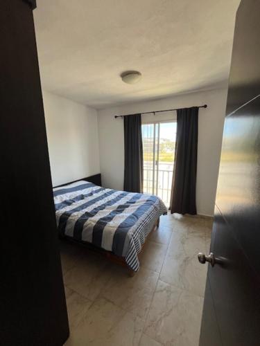 a bedroom with a bed and a door with a window at Casa Completa Cómoda en el Sur in Santa Gertrudis