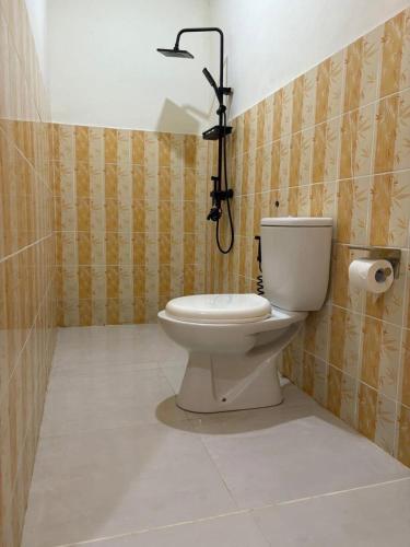 a bathroom with a toilet with a camera on the wall at Gili Glow Homestay in Gili Trawangan