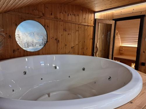 a large white bath tub in a wooden bathroom at Camping Ushuaïa Villages Le Viaduc in Arlebosc