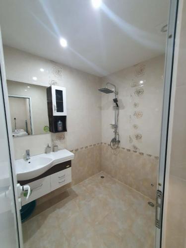 a white bathroom with a sink and a shower at Levkov in Petrich