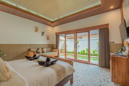 a hotel room with a bed and a television at Pondok loji villa in Ubud