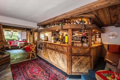a pub with a wooden bar with a rug at Hotel Gran Baita in Gressoney-Saint-Jean