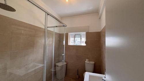 a bathroom with a glass shower and a toilet at Park Apartment - 2 Room APT in Lavradio