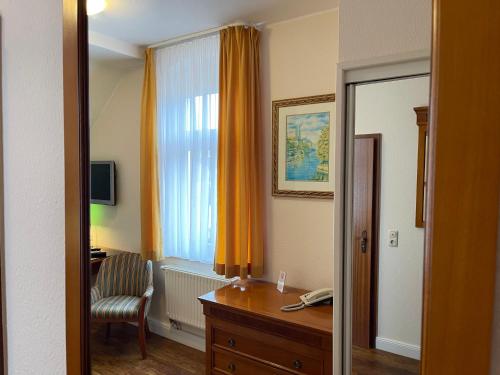 ein Zimmer mit einem Schreibtisch und einem Fenster mit einem Stuhl in der Unterkunft In Piazza in Bad Klosterlausnitz