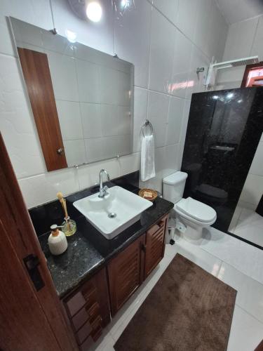 een badkamer met een wastafel, een toilet en een spiegel bij CASA 97 completa! Horário Flexível! in Santa Teresa