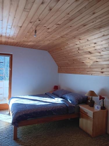 a bedroom with a bed and a wooden ceiling at Vikendica za odmor in Vlasic
