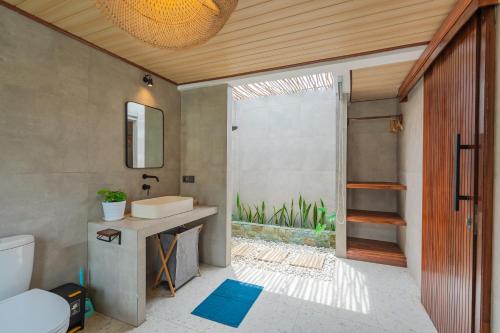 a bathroom with a sink and a toilet and a shower at Pondok loji villa in Ubud