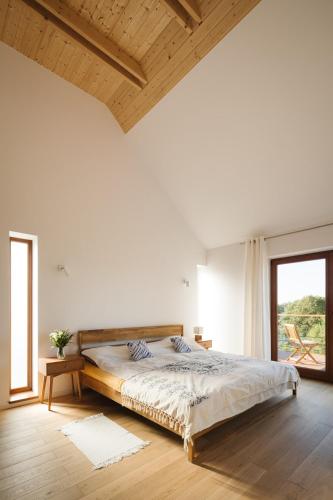 a white bedroom with a large bed and a window at Nature Home Rybical in Rybical