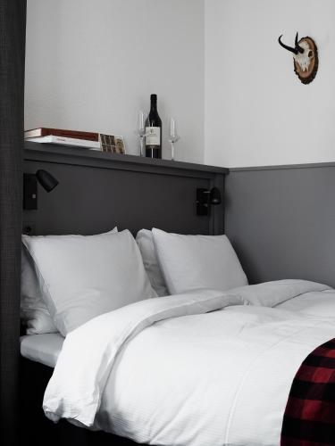 a bed with white sheets and pillows in a bedroom at Ski Lodge Engelberg in Engelberg