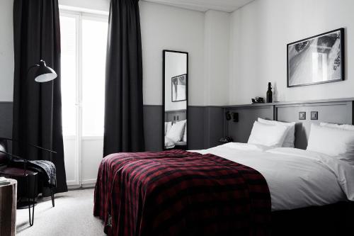 a black and white bedroom with a bed and a mirror at Ski Lodge Engelberg in Engelberg