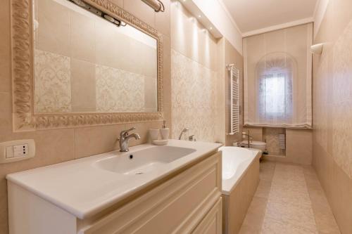 a bathroom with a sink and a tub and a mirror at Armea Suite Apartment in Trani