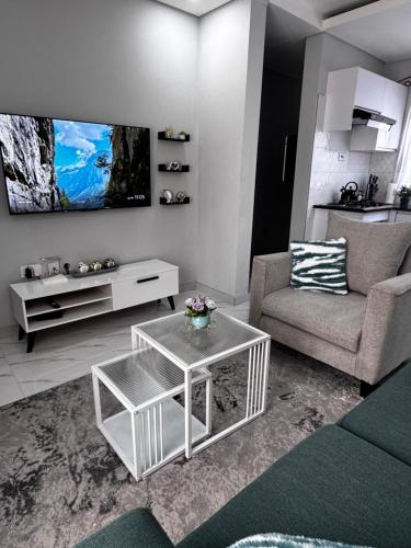 un soggiorno con un divano e un tavolo di MAITA Apartments - Silverest, Lusaka a Chongwe