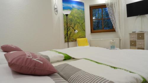 a bedroom with a bed with pillows and a window at Ferienwohnung Rhöner Luft in Bad Brückenau