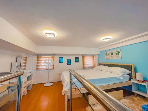 a bedroom with a bed and a desk at Woodlands Condotel in Bulan