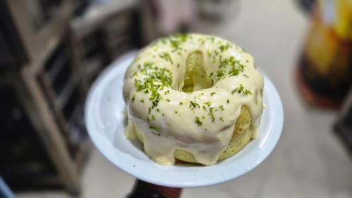 瓦拉达里斯州长市Realminas Hotel e Restaurante的盘子上放着一个淋着白色糖霜、撒着绿色糖粒的甜甜圈。