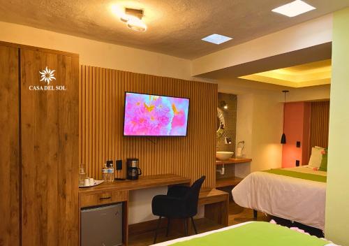 una camera d'albergo con letto e televisore a parete di Hotel Casa del Sol a San Cristóbal de Las Casas