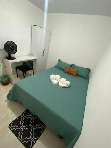 a bedroom with a blue bed with two white shoes at BARRA NOVA CASCAVEL CEARÁ-Casa Solaris in Cascavel
