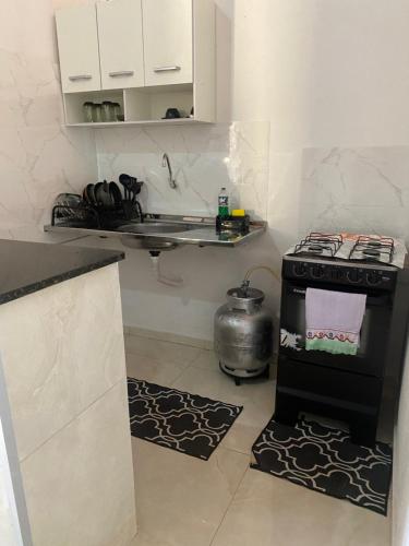 a small kitchen with a stove and a sink at BARRA NOVA CASCAVEL CEARÁ-Casa Solaris in Cascavel
