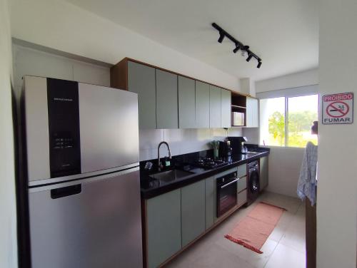 a kitchen with a stainless steel refrigerator and appliances at Apartamento 2 Quartos com Ar Condicionado in Paraty