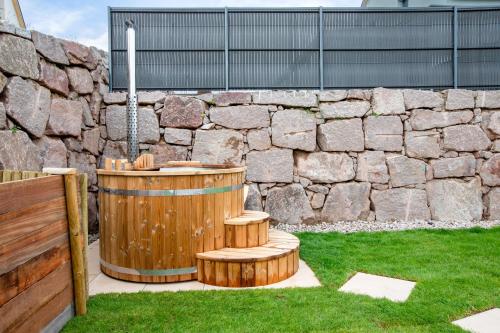 a wooden barrel sitting next to a stone wall at Rodern - Le Cocon des vignes in Rodern