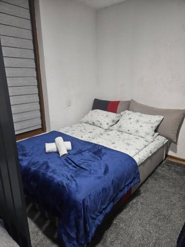 a bed with two towels on it in a bedroom at Apartmani Planinsko srce Vlašić in Vlasic