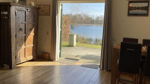 an open door with a view of a lake at Luxe villa aan het meer in Heel