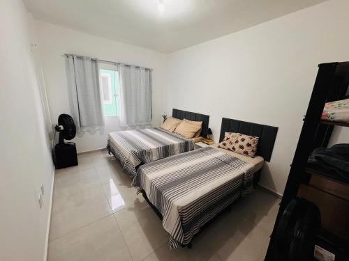 een slaapkamer met 2 bedden en een bank bij Ap 800m da praia in Rio das Ostras