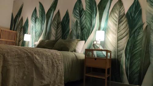 een slaapkamer met een bed met bladeren op de muur bij Arguineguín Heart in La Playa de Arguineguín