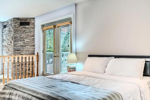 a bedroom with a large bed and a balcony at Muskoka 4-Bedroom Cottage in Port Carling