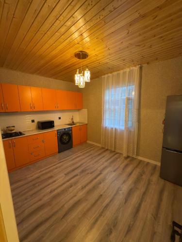 kuchnia z pomarańczowymi szafkami i drewnianym sufitem w obiekcie Villa Qecres w mieście Küpçal