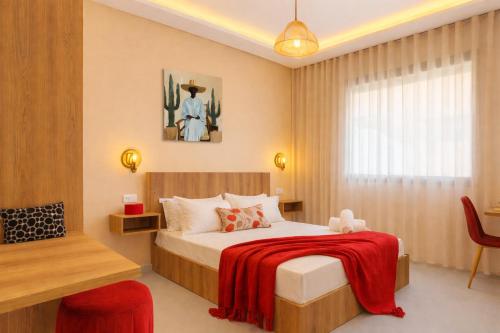 a bedroom with a bed with a red blanket at Cactus Apartment - Walk to Surf Beaches, Rooftop View, Remote Work, Free Parking, AC in Agadir nʼ Aït Sa