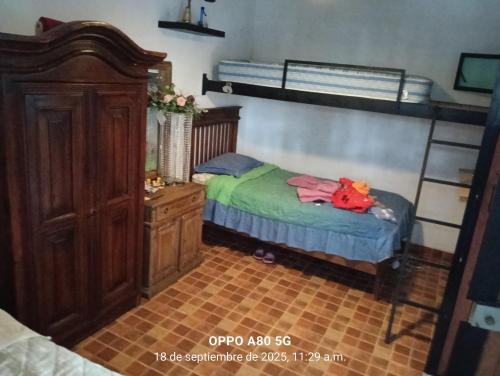 a small bedroom with a bed and a wooden cabinet at Casa ixcanul in Montitlán