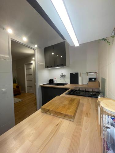 a kitchen with a wooden counter top in a room at Apartament Toruń Orbita free parking in Toruń